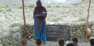 A Baloch women teaching students in a school in Balochistan without boundry and buildings